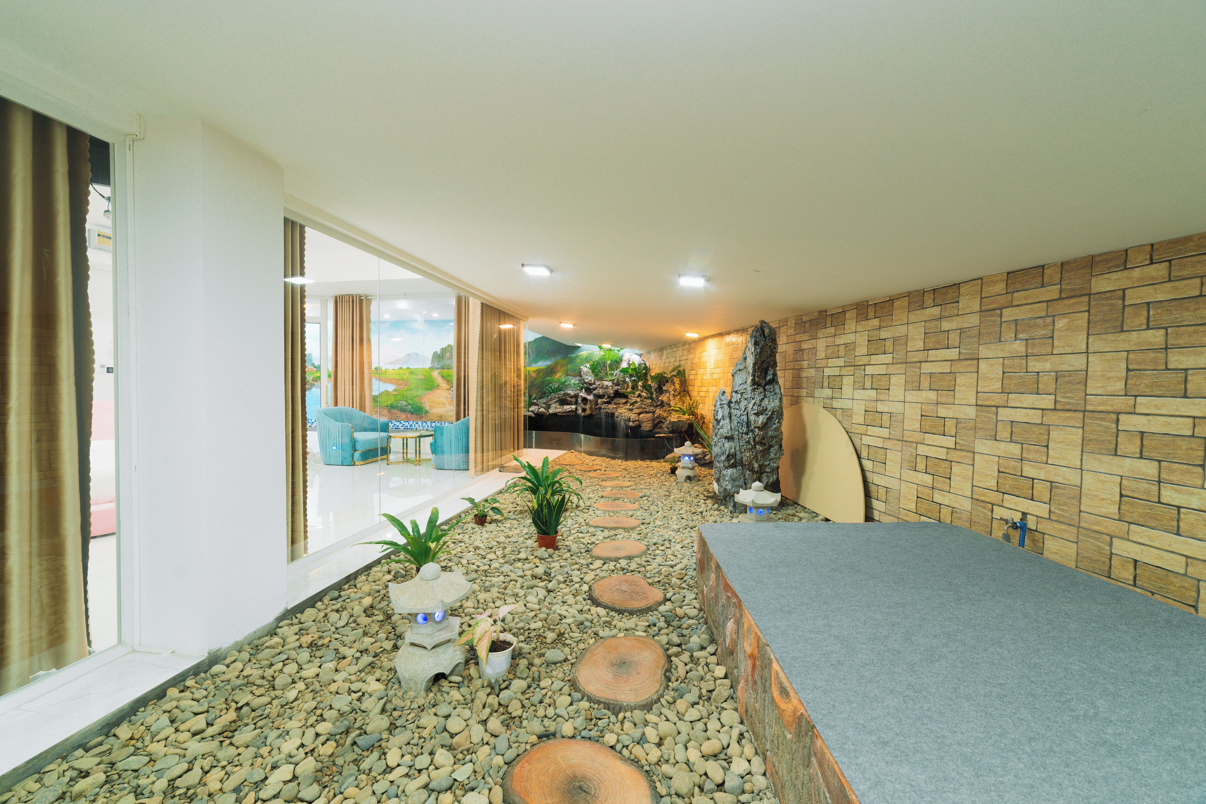 A spa area with a pebble path, seating area, and a stone wall.