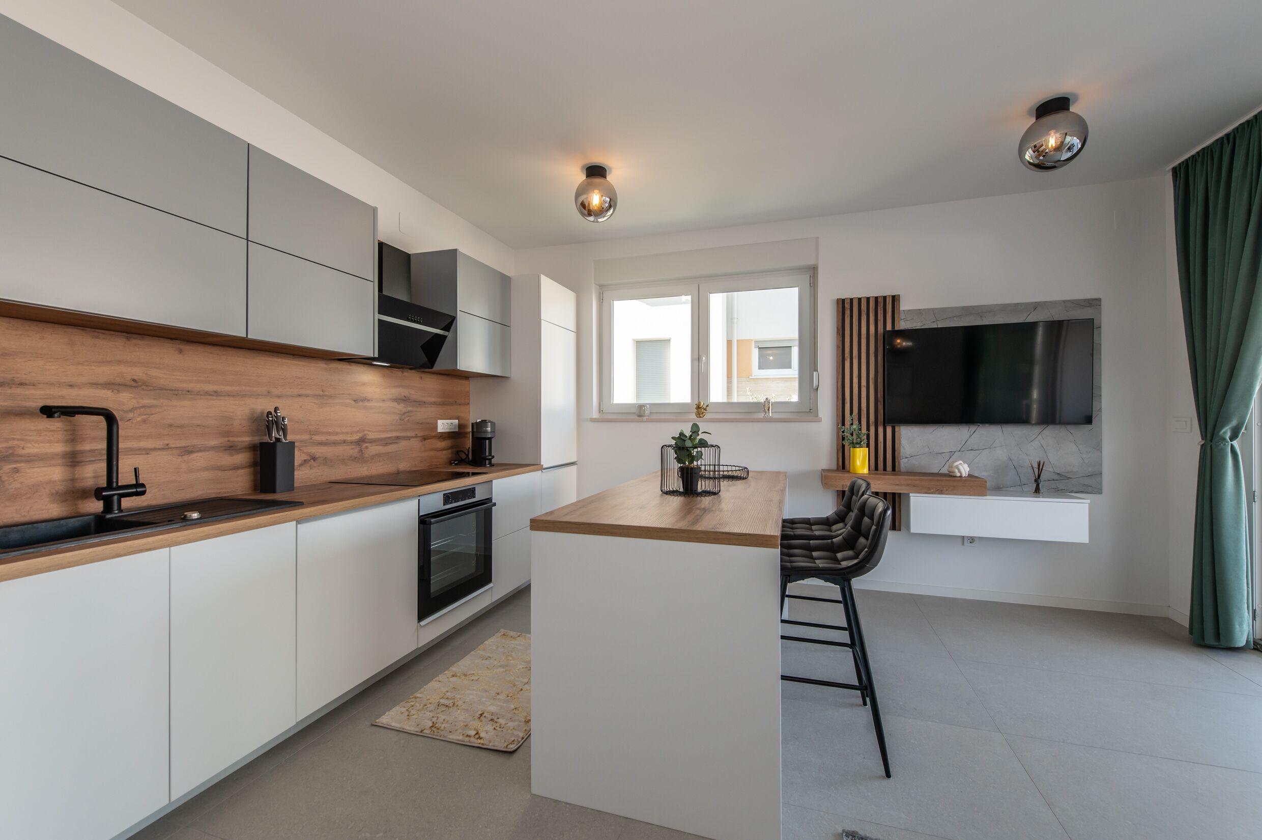 A modern kitchen with a wooden countertop, white cabinets, and a built-in stove.