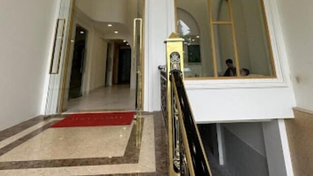 A spacious interior with high arched windows, a chandelier, and a red carpet leading to a staircase. - Hala Hotel - by Bay Luxury (Ho Chi Minh City)