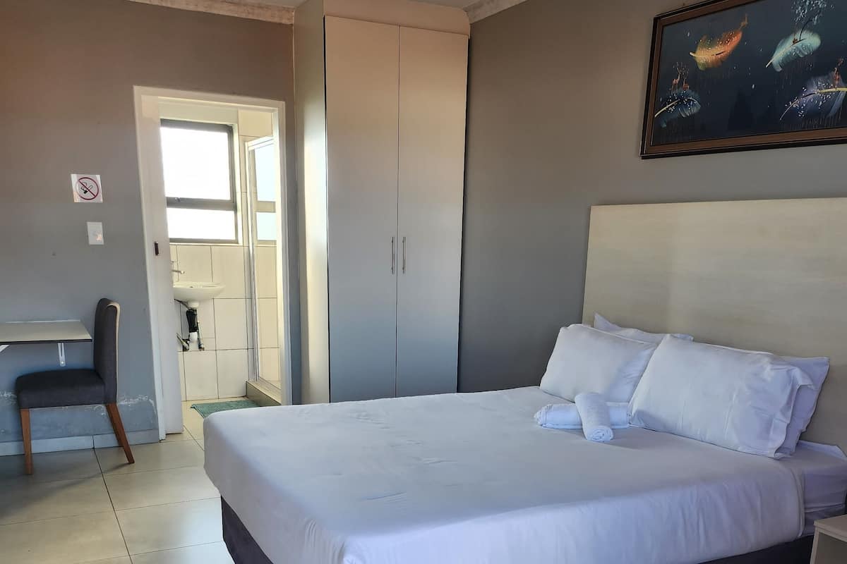 Ein Schlafzimmer mit einem großen Bett, einem Schreibtisch und einem Kleiderschrank.