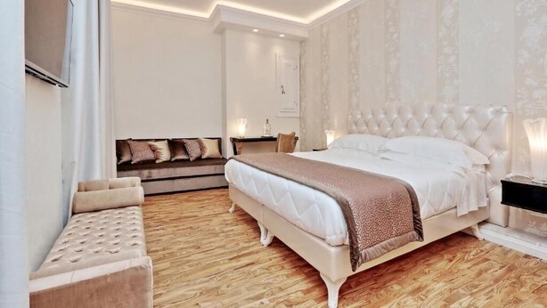 Un dormitorio con una cama grande, un sofá y un televisor.