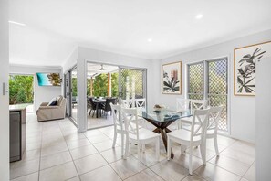 A modern kitchen with white cabinetry, a built-in oven, and a stainless steel refrigerator. - Mudjimba Retreat-Peaceful Luxury (Sunshine Coast)