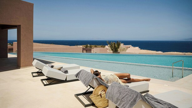 Ein Poolbereich mit Liegestühlen und Blick auf den Ozean.