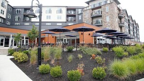 A modern building with outdoor seating and a landscaped garden area.