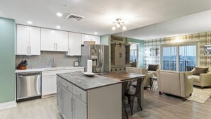 A modern kitchen with white cabinets, stainless steel appliances, and a central island.