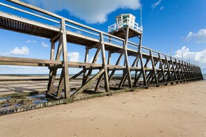 Une jetée en bois s’avançant dans l’eau, avec une tour d’observation à son extrémité.