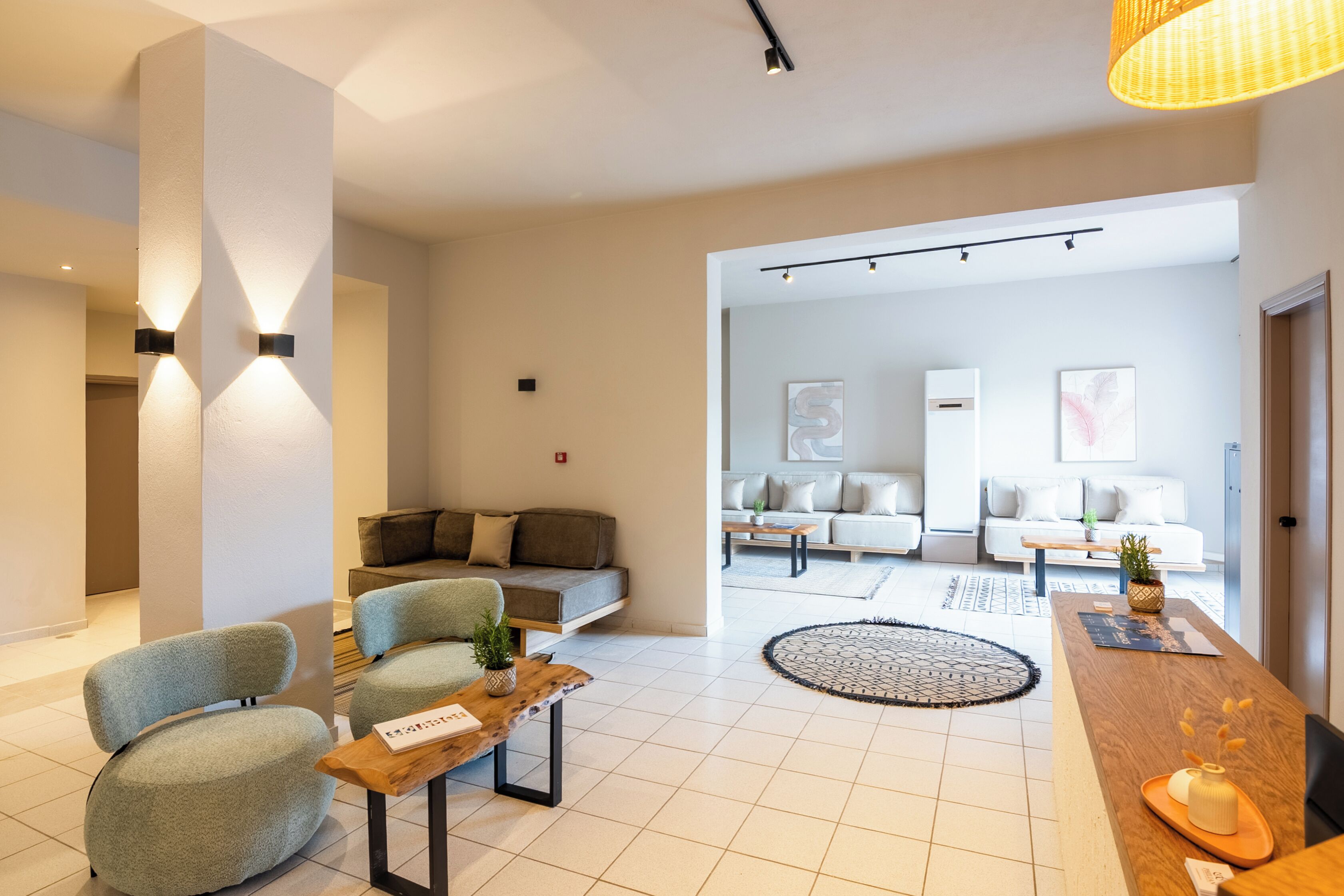Una sala de estar moderna con un sofá, sillas, una mesita de centro y un comedor con una mesa de madera y sillas.