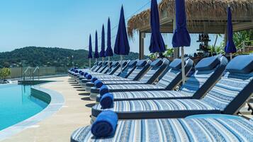 Een seizoensgebonden buitenzwembad, parasols voor strand/zwembad