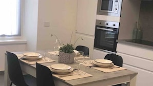 Un coin repas avec une table dressée pour quatre personnes, un four à micro-ondes et un four en arrière-plan.