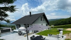 Una casa con patio, arredi esterni e piscina.