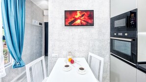 A modern kitchen with a white table, two cups of coffee, and fruit. - HB apartments Aghmashenebeli III (Tbilisi)