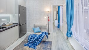 A compact kitchen with a modern refrigerator and a small dining area. - HB apartments Aghmashenebeli III (Tbilisi)