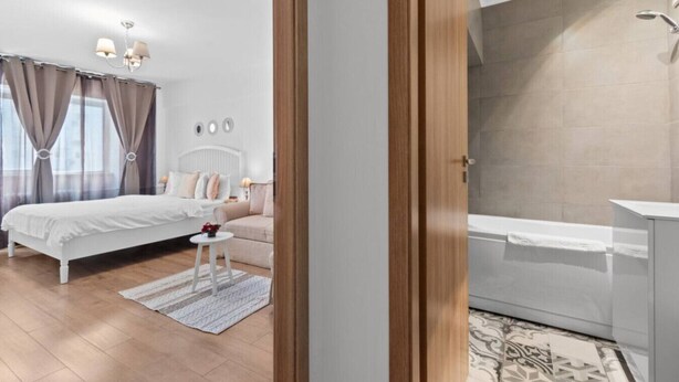 A bedroom with a bed, bedside table, and a nightstand.