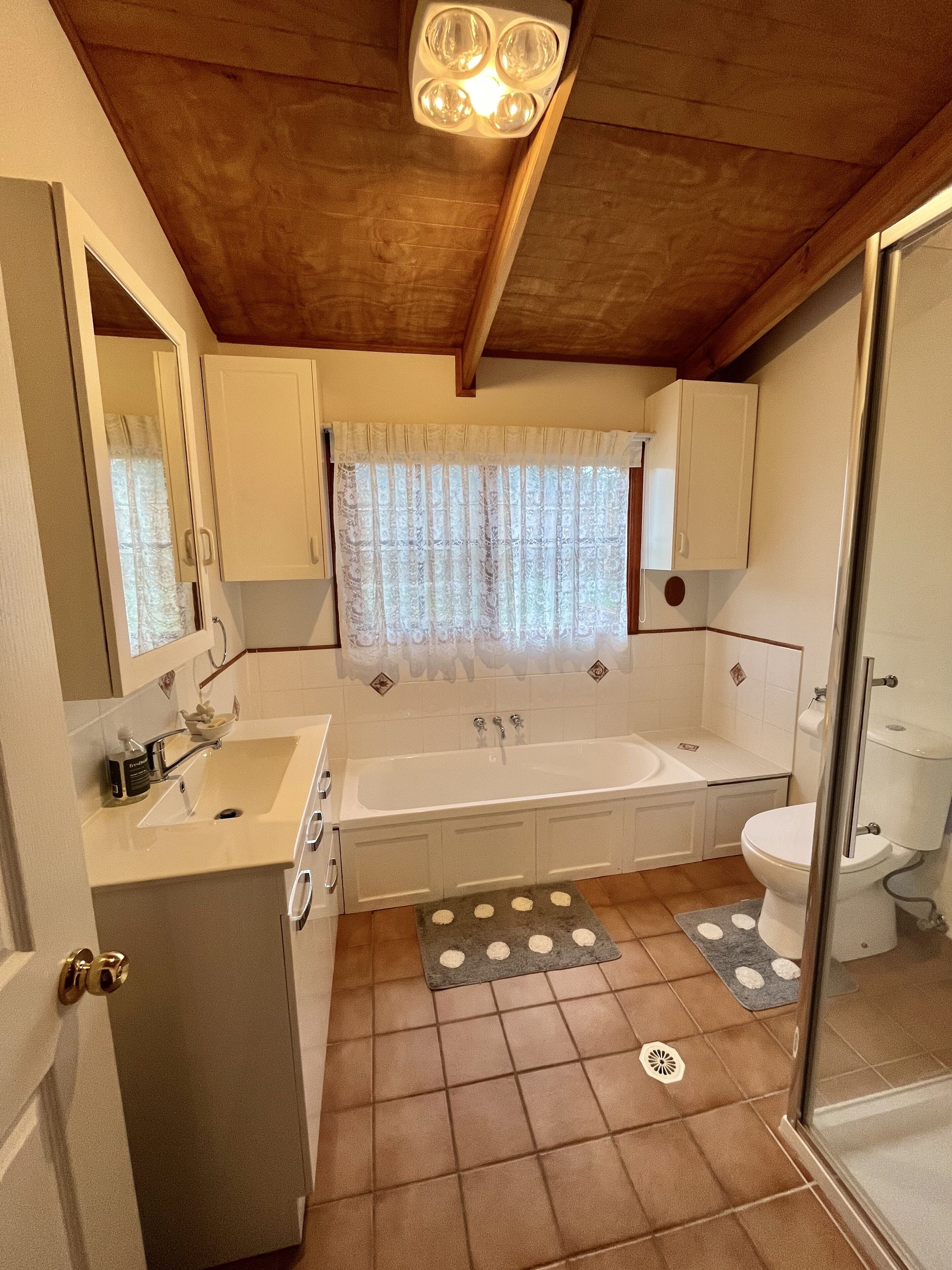 A compact, well-lit bathroom with a bathtub, toilet, and sink.