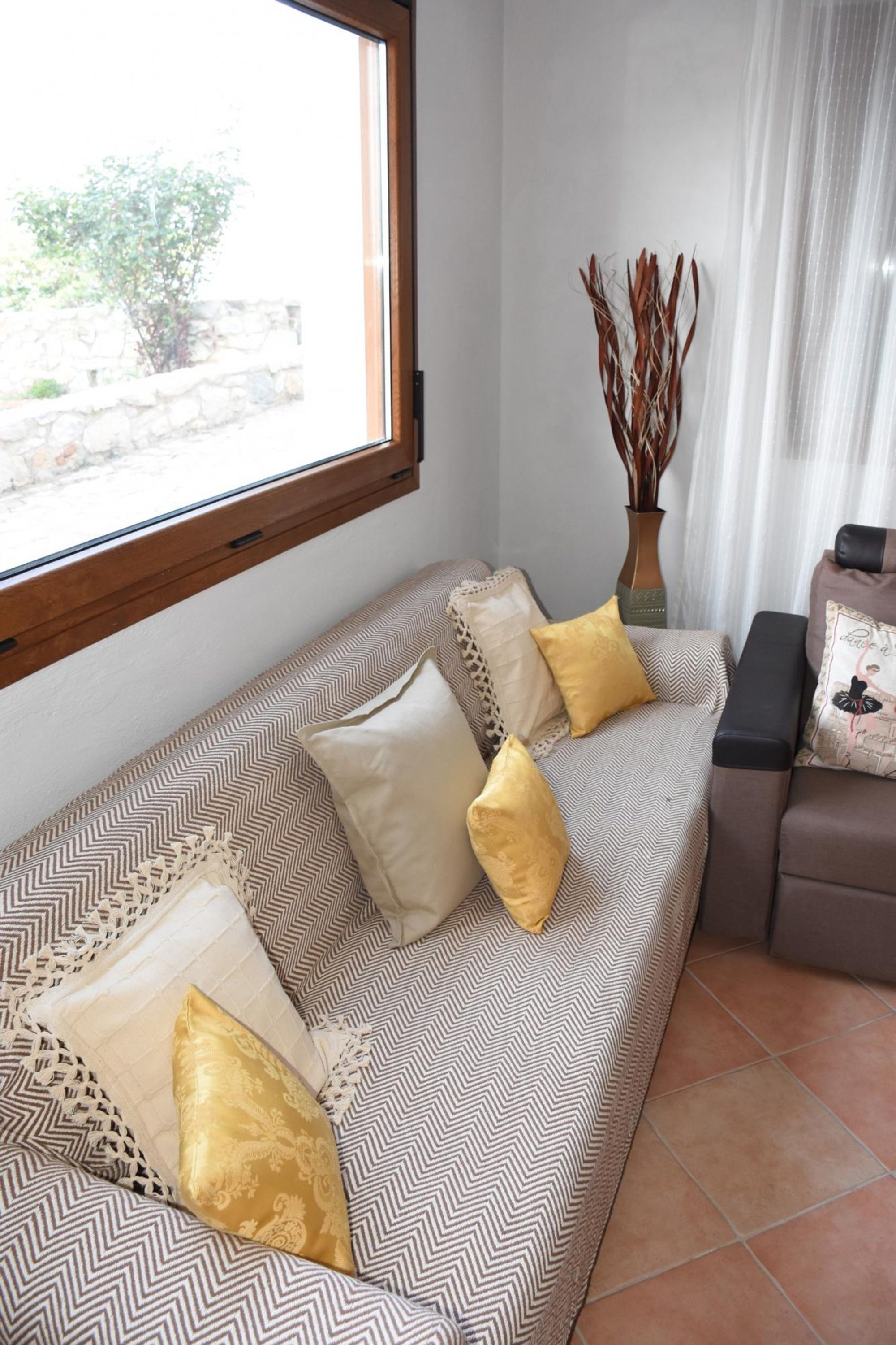 A living room with a sofa, a bench, and a window.