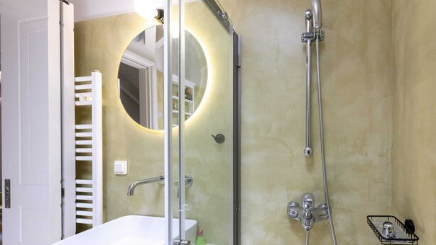 Une salle de bain avec une douche, un lavabo et un miroir.
