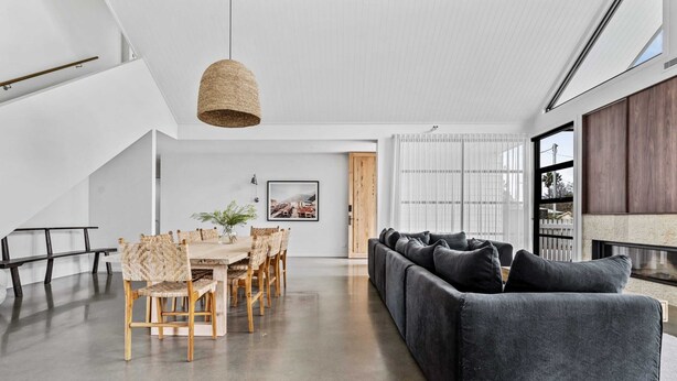 A modern interior with a dining area, a sofa, and a hanging light fixture. - Maple Suite, Berry - by Linnaeus Collection (Berry)