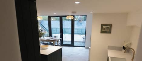 Een moderne keuken met een centraal eiland, een inbouwoven en een gootsteen met een gouden kraan.