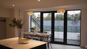 A modern kitchen with a dining area, large windows, and a view of the outside. - Cosy Central Townhouse in Woodstock (Woodstock)