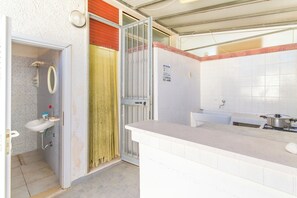 A kitchen with a white countertop, a sink, and a stove. - Villetta Rossa with garden (Melendugno)