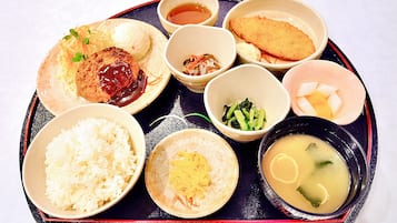 A tray with various Japanese dishes including rice, soup, and several small bowls of side dishes.