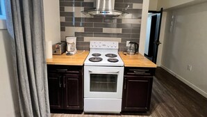 A compact kitchen with a gas stove, a coffee maker, and a toaster. - Dt 1Bed 1bath Cozy Suite 8 Min Walk To Arena (Edmonton)