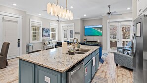 A modern kitchen with a large island, built-in appliances, and a dining area with a view. - 30A | Gorgeous Home | Resort Pool (Rosemary Beach)