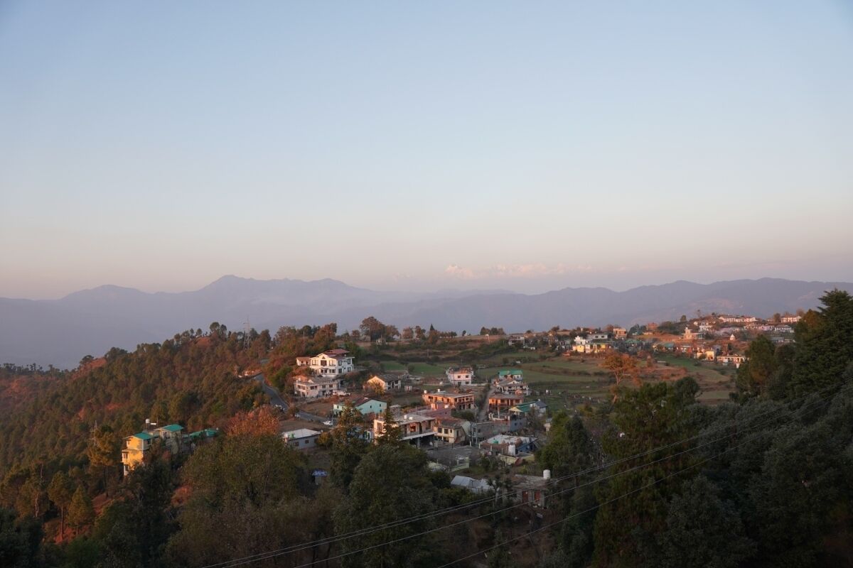 A hillside village with houses and a prominent building in the center.