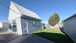 A residential property with a small house, a fenced yard, and a tree. - Private Studio | Convenient Stay Near Hobart (Claremont)