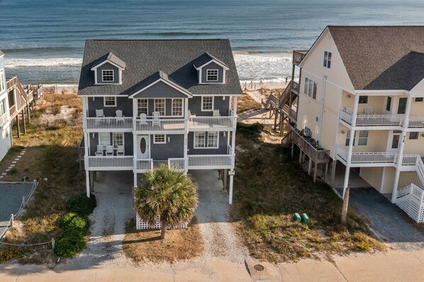 A two-story beach house with a balcony, a covered porch, and a view of the ocean. - 'Sea Dawg (North Topsail Beach)