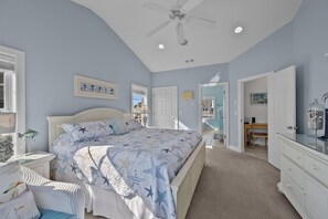 A bedroom with a large bed, a ceiling fan, and a view to the outside. - 'Sea Dawg (North Topsail Beach)