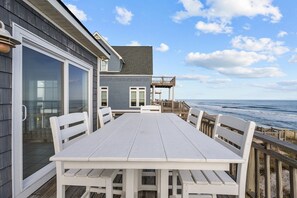A deck with a table and chairs overlooking the ocean. - 'Sea Dawg (North Topsail Beach)