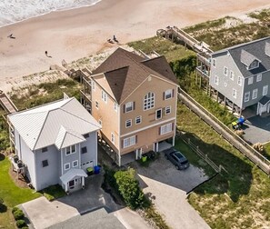 An aerial view of a coastal residential area with houses, a beach, and a pier. - A Shore Thing - 6BR Oceanfront House in North Topsail - Sleeps 16 (North Topsail Beach)