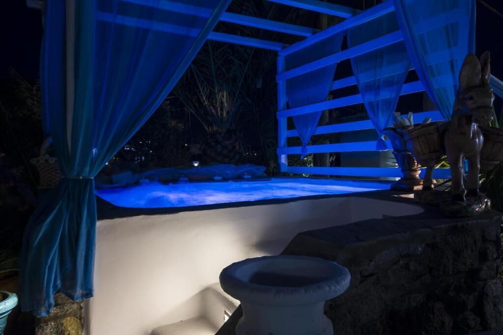 Zona de piscina con una estructura de piedra y una estatua de burro.