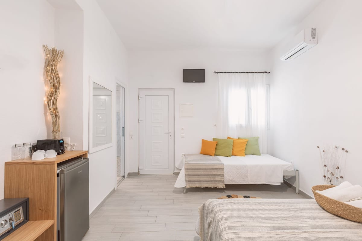 Une chambre à coucher au style minimaliste, comprenant un lit, une table de chevet et un petit coin cuisine.