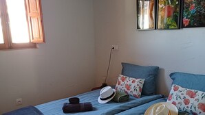 A room with two beds, a window, and a wall-mounted picture. - Casita of Casa Olivar (Tocón)