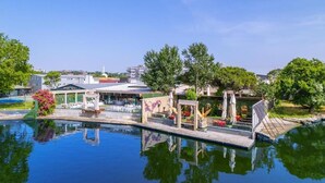 A swimming pool with a deck area, surrounded by greenery and buildings in the background. - La Pearl Konaklama (Istanbul)