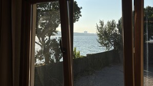 A window with a view of a body of water and trees. - La Pearl Konaklama (Istanbul)