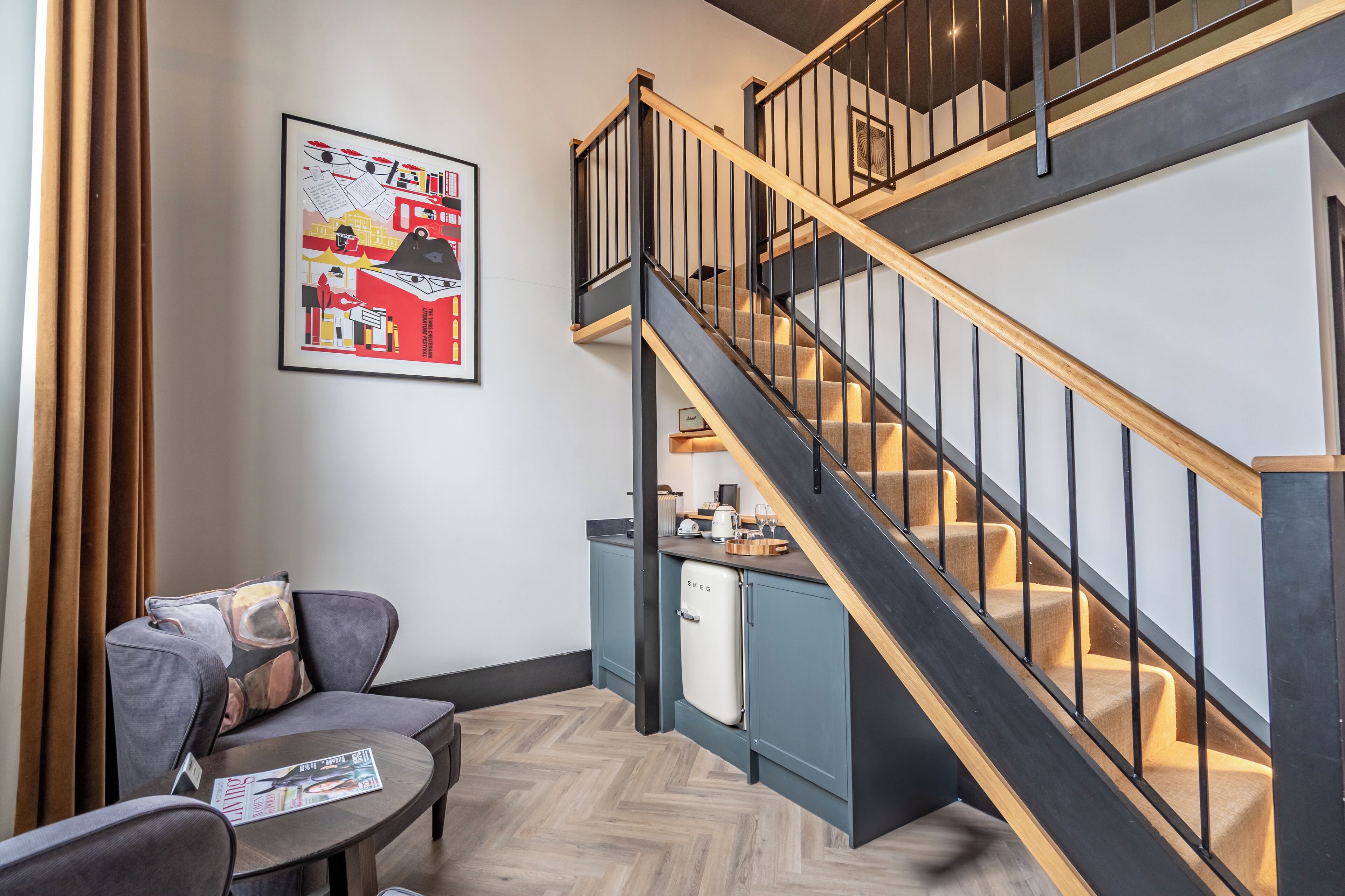 Un interior moderno con una escalera, una zona de comedor y una cocina.