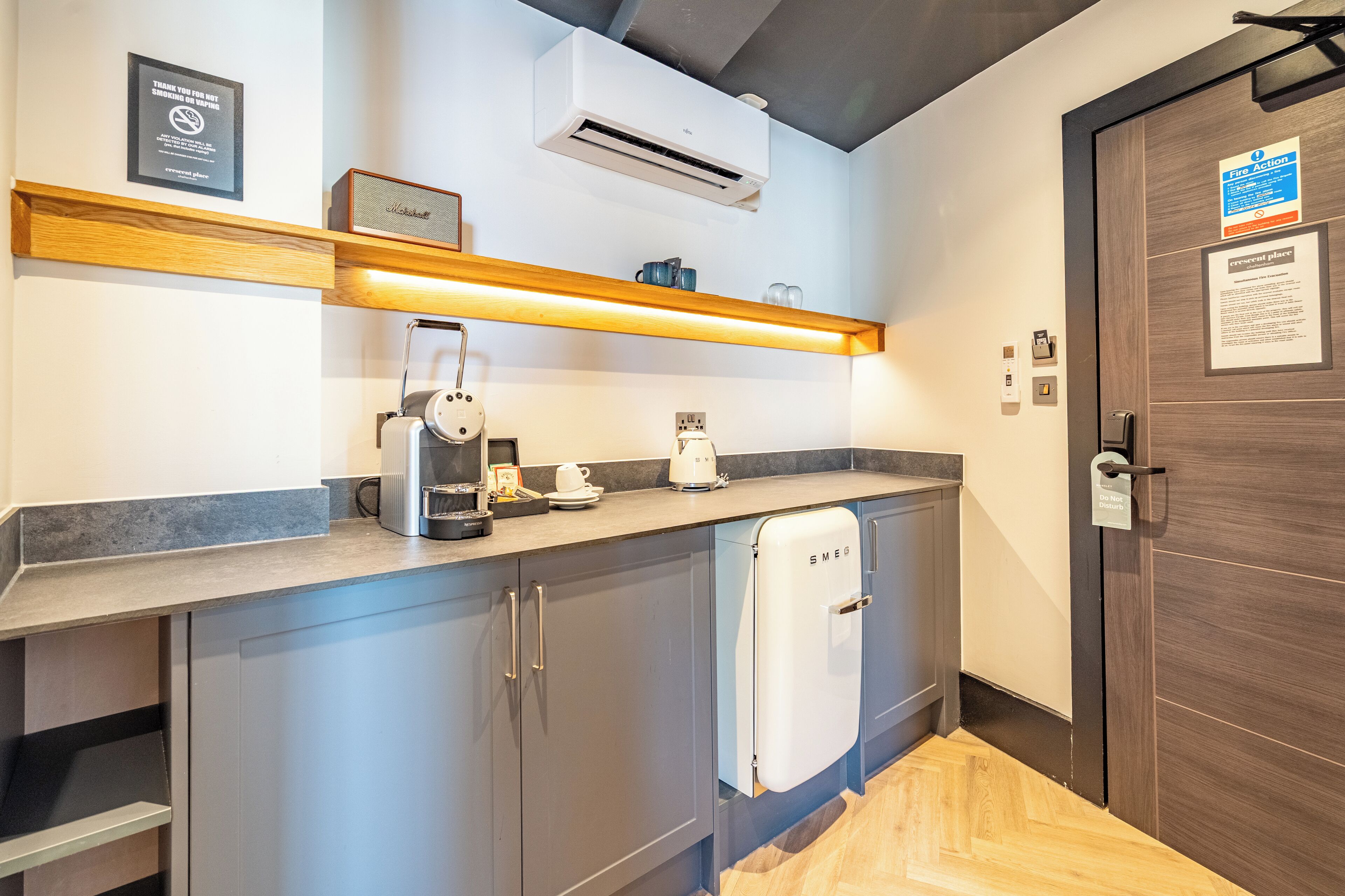 A modern kitchen with a built-in coffee maker, a kettle, and a white refrigerator.