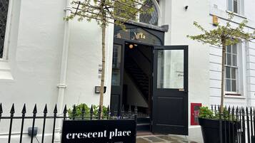 A building entrance with a sign for 'Crescent Place' and a staircase leading inside.