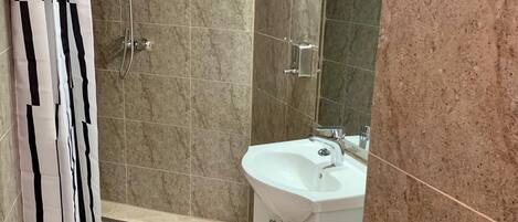 Un baño moderno con ducha, inodoro y lavamanos.