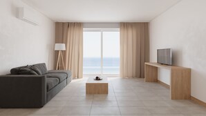A modern living room with a sofa, a coffee table, a TV on a wooden stand, and a view of the sea through large windows. - Hotel Delfino (Marciana)