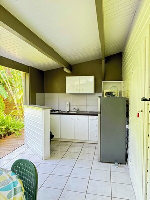 A compact kitchen with white cabinets, a sink, and a microwave.