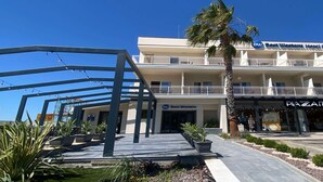 A hotel with a balcony, outdoor seating, and a palm tree. - Best Western Hotel Massafra (Massafra)