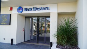The entrance to Best Western hotel with a glass door and a sign above.