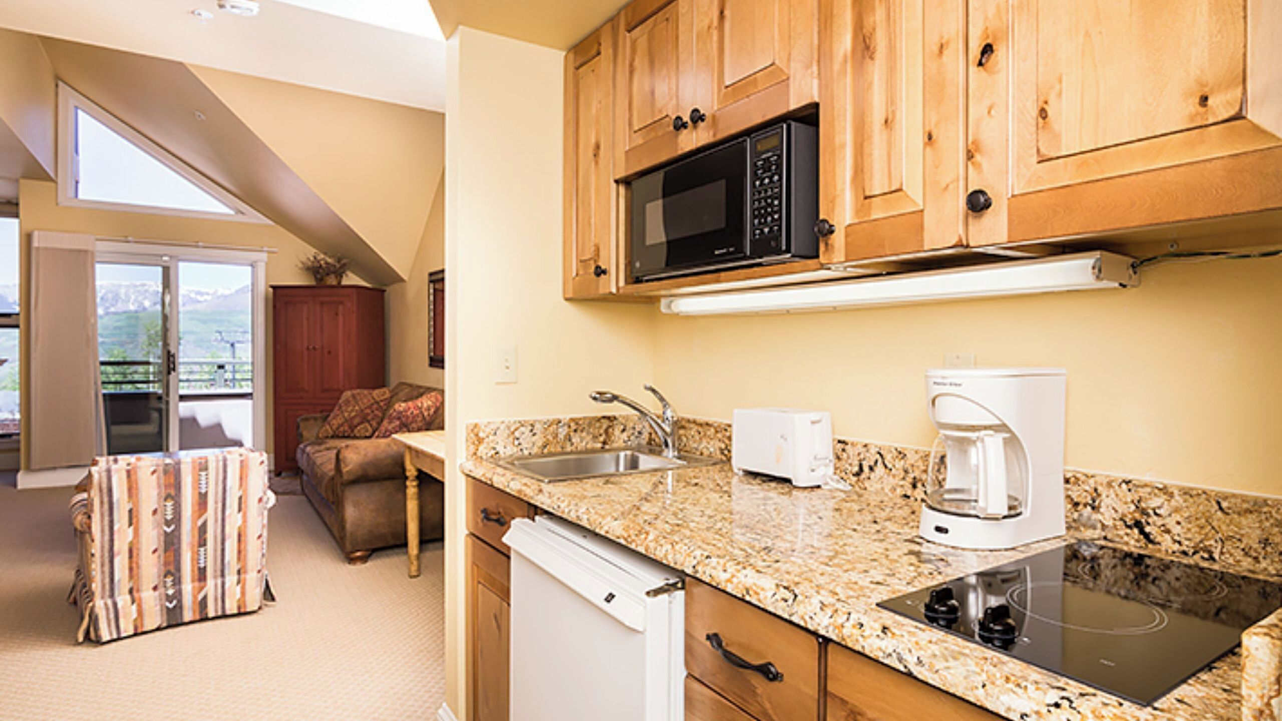 A kitchen with a microwave, coffee maker, and dishwasher.