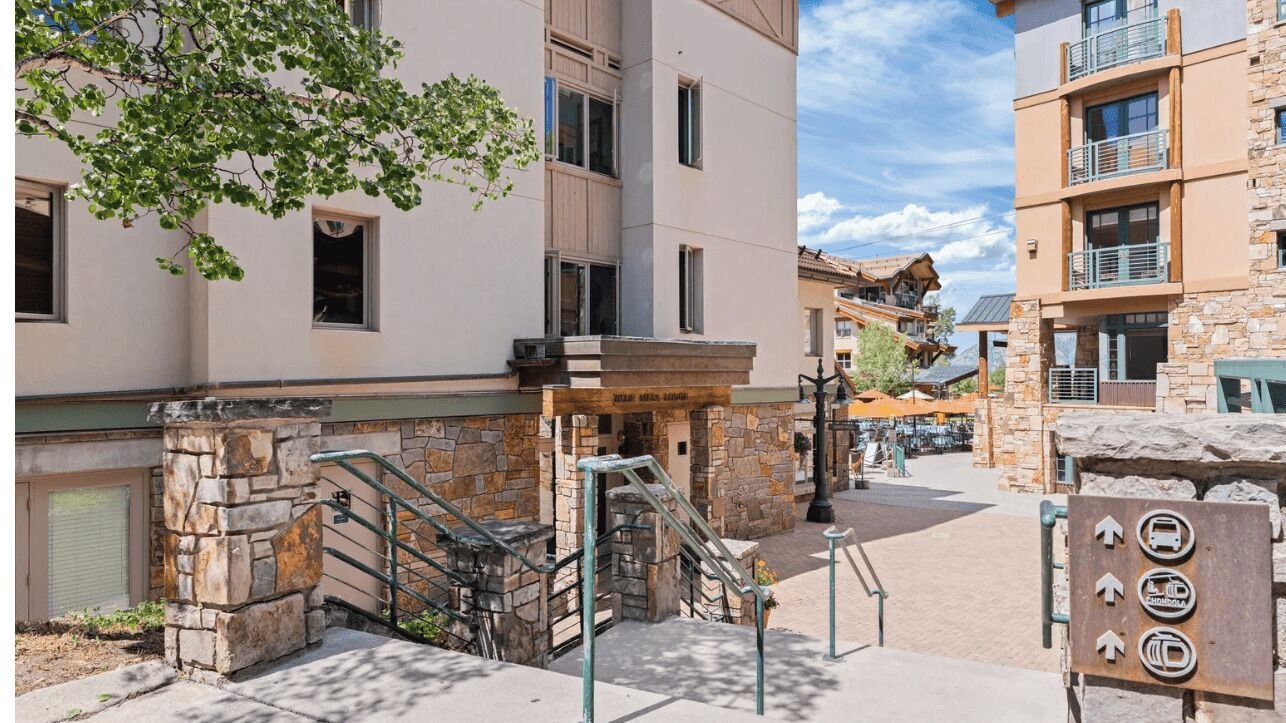 A hotel with a stone facade, a staircase, and a sign indicating amenities.