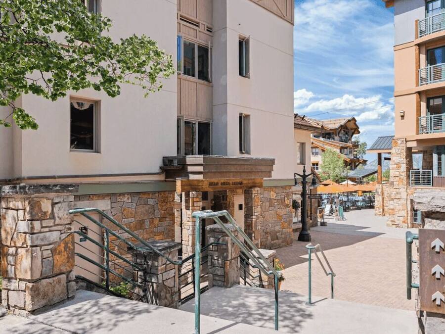A hotel with a stone facade, a staircase, and a sign indicating amenities.