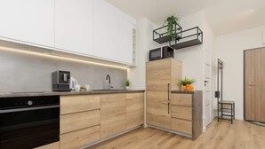 Eine moderne Küche mit Holzausstattung, einer eingebauten Mikrowelle und einer Kaffeemaschine.